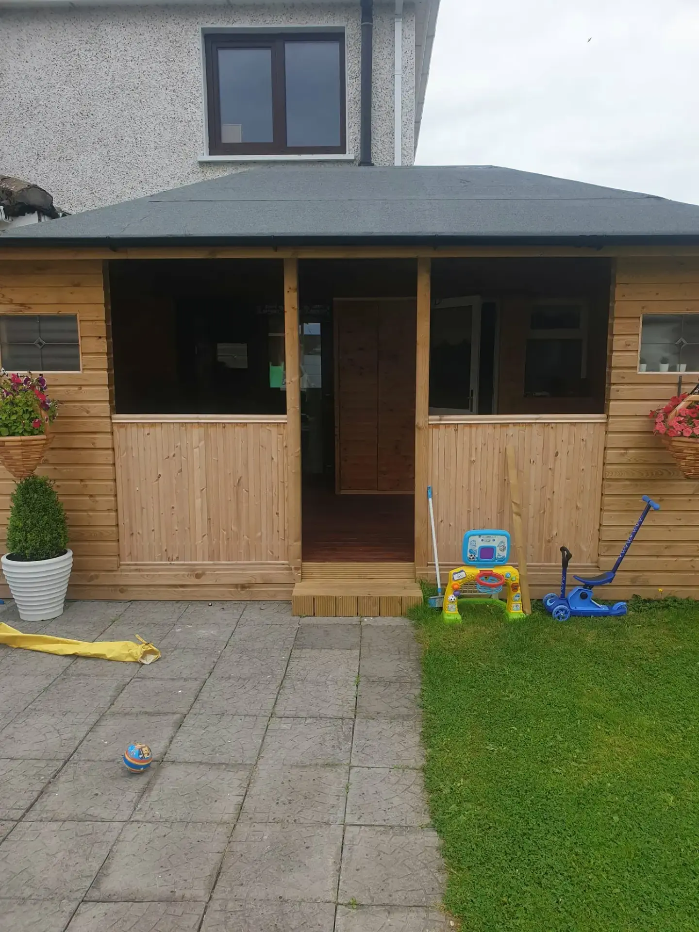 Completed timber-clad home extension with felt roof and large windows