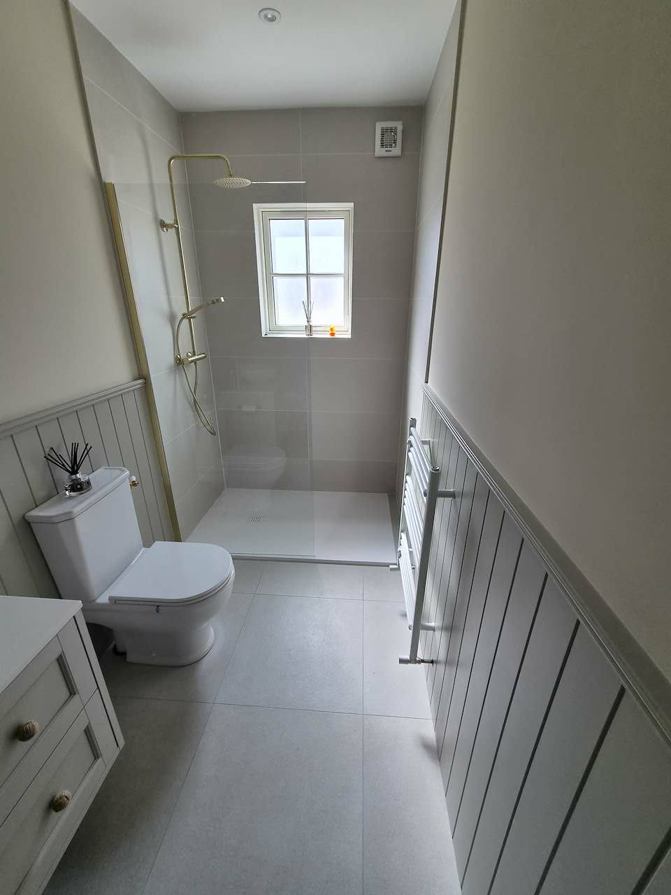 Renovated bathroom with walk-in shower, brass fittings and panelled walls